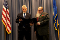 Mike reads the retirement certificate.