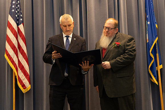 Mike reads the retirement certificate.
